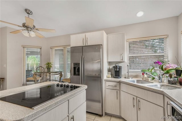 kitchen with black electric cooktop, stainless steel fridge with ice dispenser, a wealth of natural light, and sink