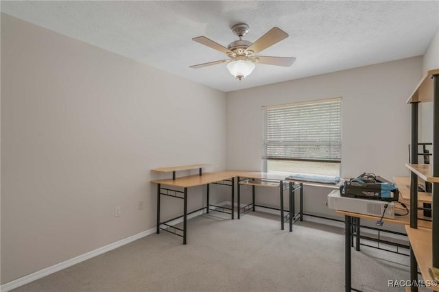 office space with light carpet, a textured ceiling, and ceiling fan