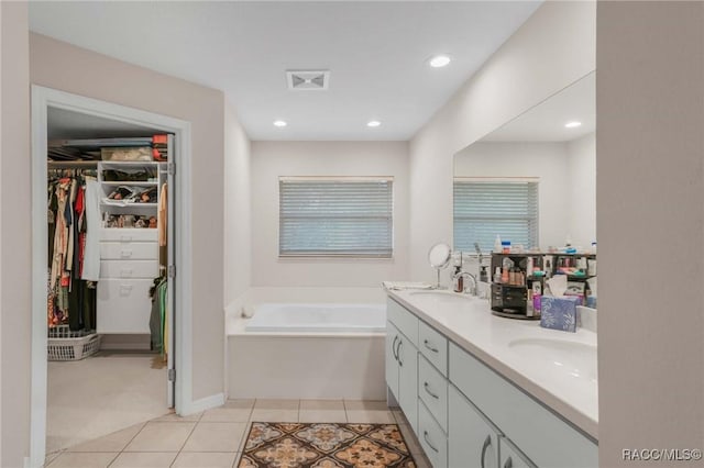 bathroom with vanity, a tub, and tile patterned floors