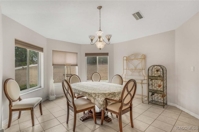 tiled dining space featuring a chandelier