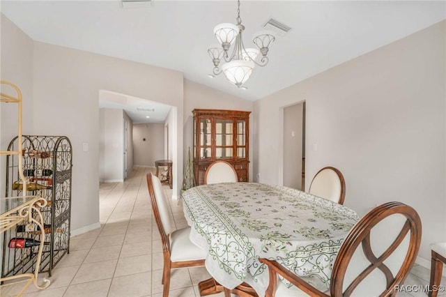 tiled dining area featuring lofted ceiling and a chandelier