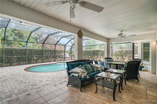 view of swimming pool featuring an outdoor living space, a lanai, ceiling fan, and a patio area