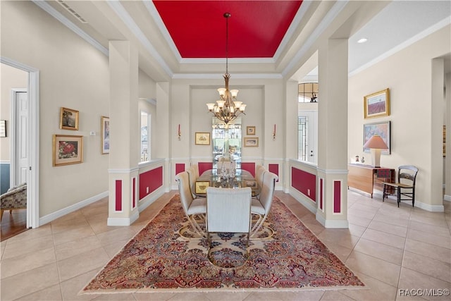 dining space featuring an inviting chandelier, light tile patterned floors, ornamental molding, and a tray ceiling