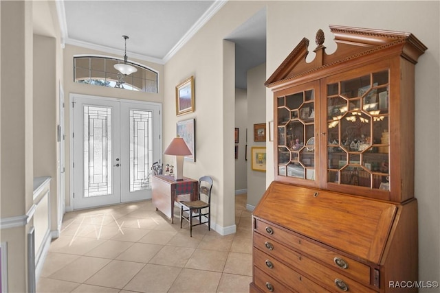 entryway featuring light tile patterned floors, crown molding, and french doors