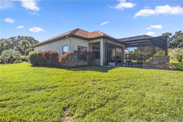 back of house featuring a lanai and a yard