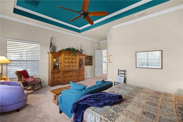 carpeted bedroom with crown molding, ceiling fan, and a tray ceiling