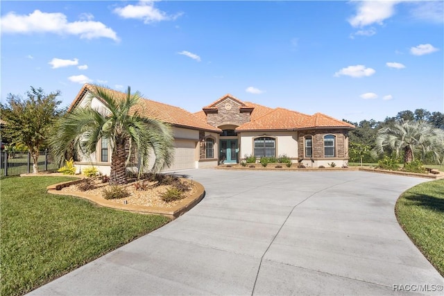 mediterranean / spanish home with a garage and a front yard