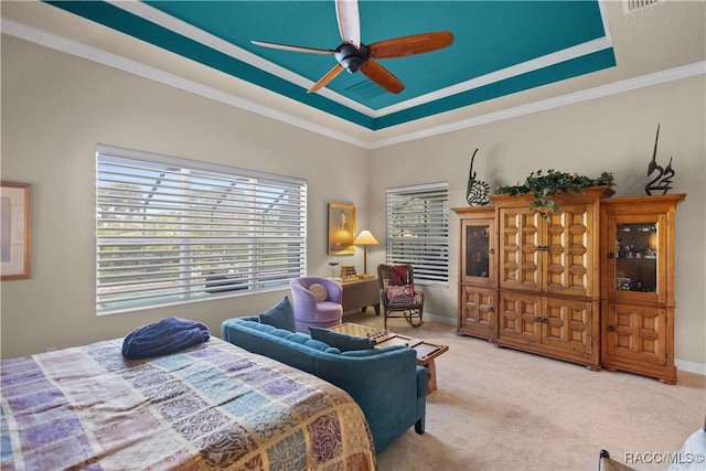 bedroom featuring a tray ceiling, ceiling fan, ornamental molding, and light colored carpet