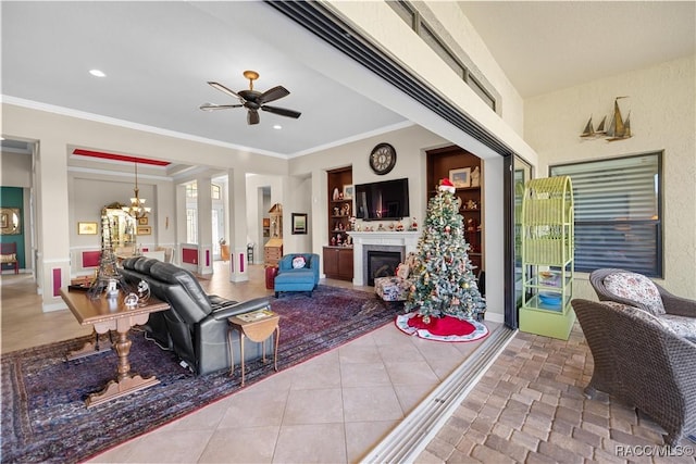 tiled living room with crown molding and ceiling fan with notable chandelier