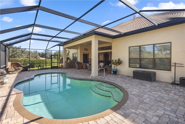 view of swimming pool featuring glass enclosure, ceiling fan, and a patio area