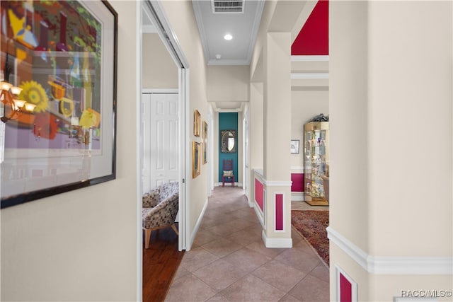 hall with light tile patterned floors and ornamental molding