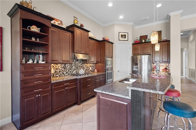 kitchen with a kitchen breakfast bar, sink, appliances with stainless steel finishes, and an island with sink