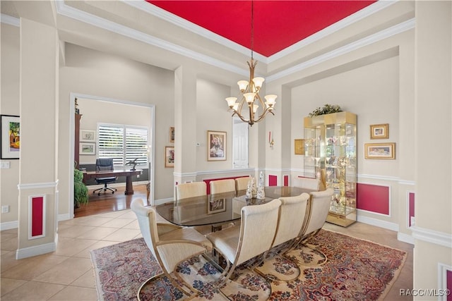 tiled dining space with crown molding, a raised ceiling, a high ceiling, and a notable chandelier