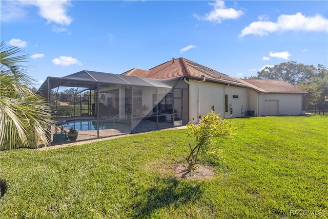 back of property with a lawn, glass enclosure, and central AC unit