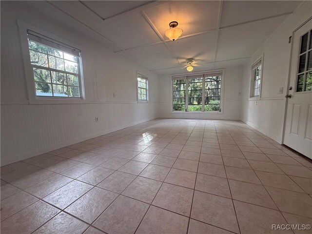 5217 Riverside Dr, Yankeetown, FL 34498 - unfurnished room with light tile patterned floors, ceiling fan, and a wainscoted wall