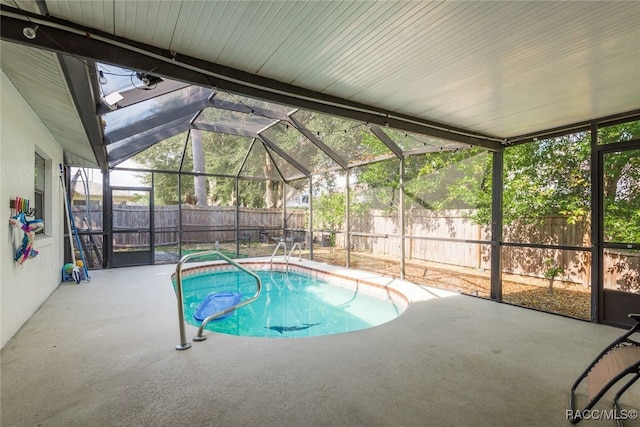 view of swimming pool with a lanai and a patio area