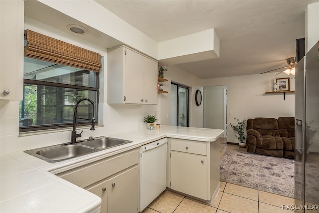 kitchen featuring ceiling fan, sink, kitchen peninsula, tile countertops, and white dishwasher