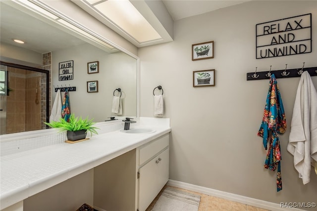 bathroom with tile patterned flooring, vanity, and walk in shower