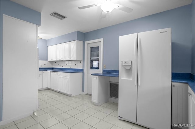 kitchen with white cabinetry, tasteful backsplash, light tile patterned floors, ceiling fan, and white appliances