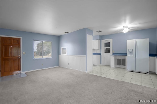 unfurnished living room featuring light tile patterned floors and ceiling fan