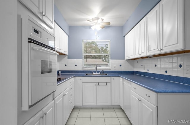 kitchen with sink, light tile patterned floors, white appliances, ceiling fan, and white cabinetry