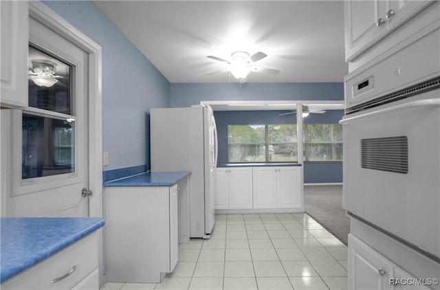 kitchen with ceiling fan, light tile patterned floors, white cabinets, and white appliances