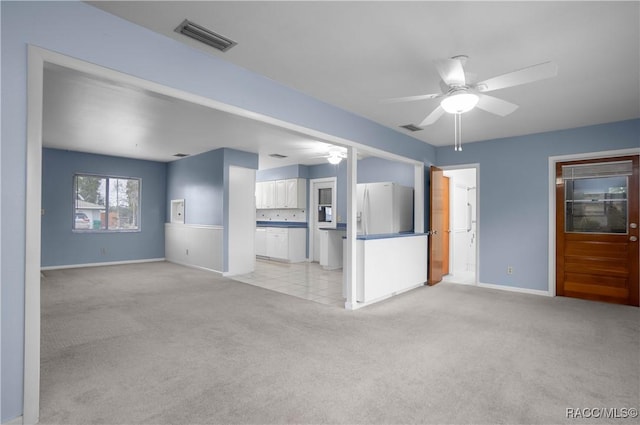 unfurnished living room featuring light carpet and ceiling fan