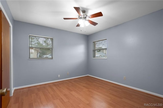 empty room with light hardwood / wood-style flooring, plenty of natural light, and ceiling fan