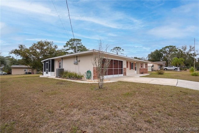 ranch-style home with cooling unit, a garage, and a front lawn