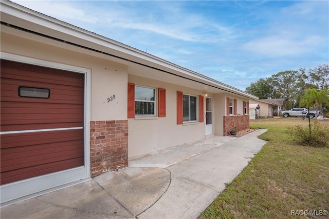 entrance to property with a yard and a patio area