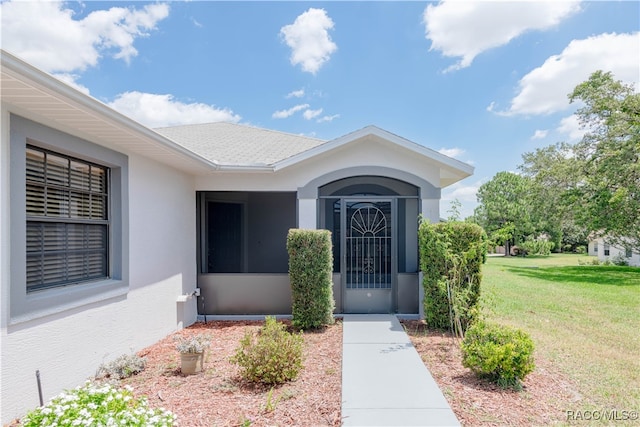 property entrance featuring a lawn