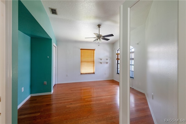 unfurnished living room featuring wood-type flooring, a textured ceiling, and ceiling fan