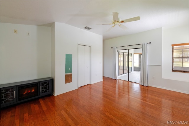 empty room featuring hardwood / wood-style flooring, ceiling fan, and a fireplace