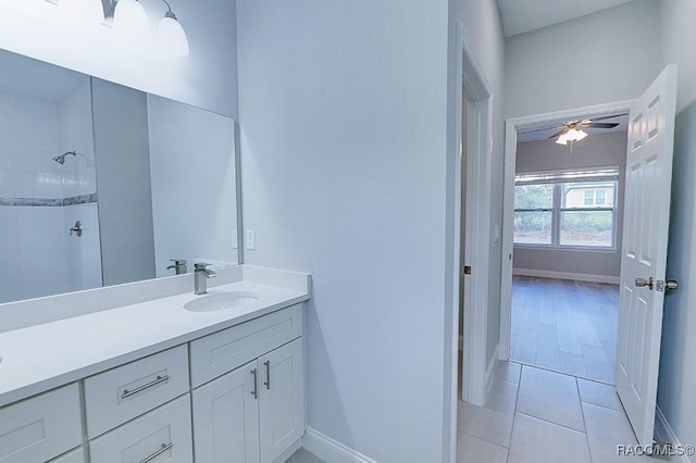 bathroom with a tile shower, ceiling fan, tile patterned flooring, and vanity