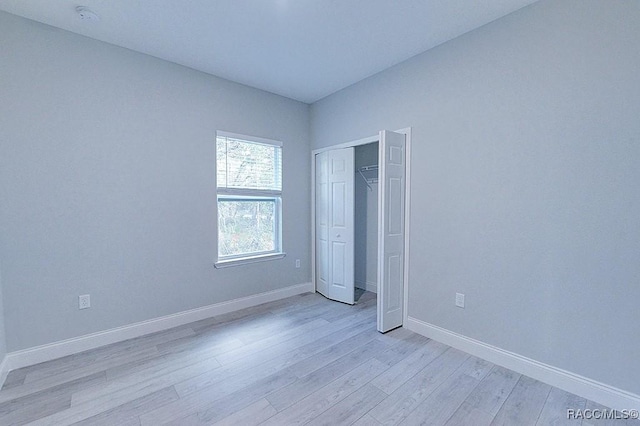 unfurnished bedroom featuring a closet and light hardwood / wood-style flooring