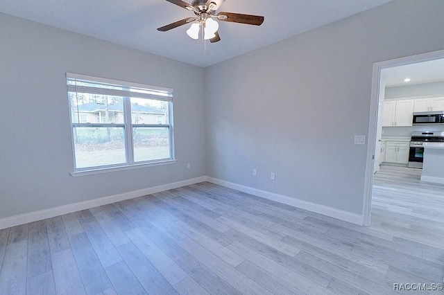 spare room featuring light hardwood / wood-style floors and ceiling fan