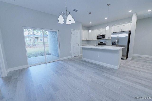 kitchen with white cabinets, stainless steel appliances, light hardwood / wood-style flooring, and hanging light fixtures