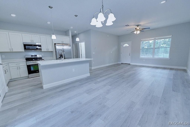 kitchen with ceiling fan with notable chandelier, hanging light fixtures, appliances with stainless steel finishes, light hardwood / wood-style floors, and white cabinetry