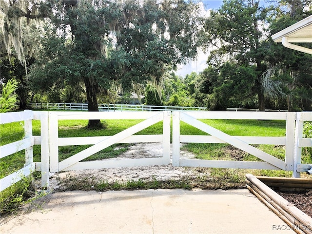 view of gate with a lawn