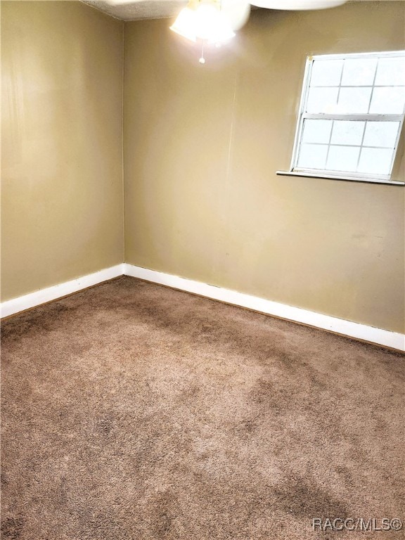 carpeted empty room featuring ceiling fan