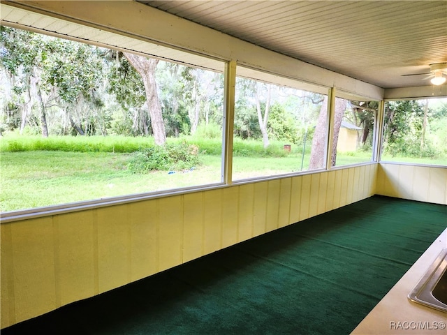 unfurnished sunroom featuring ceiling fan