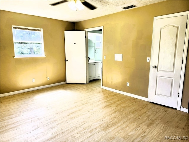 unfurnished bedroom featuring ceiling fan, light hardwood / wood-style flooring, and a textured ceiling