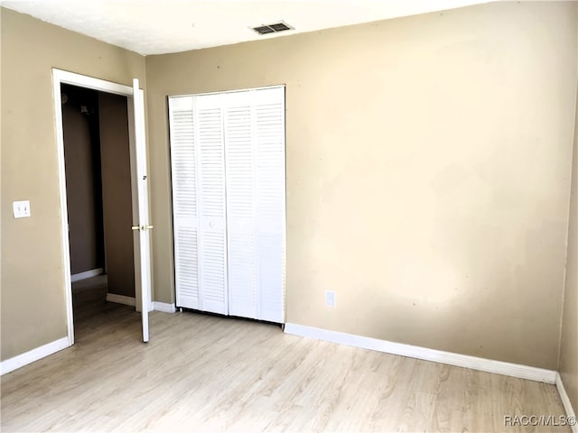 unfurnished bedroom with a closet and light hardwood / wood-style flooring