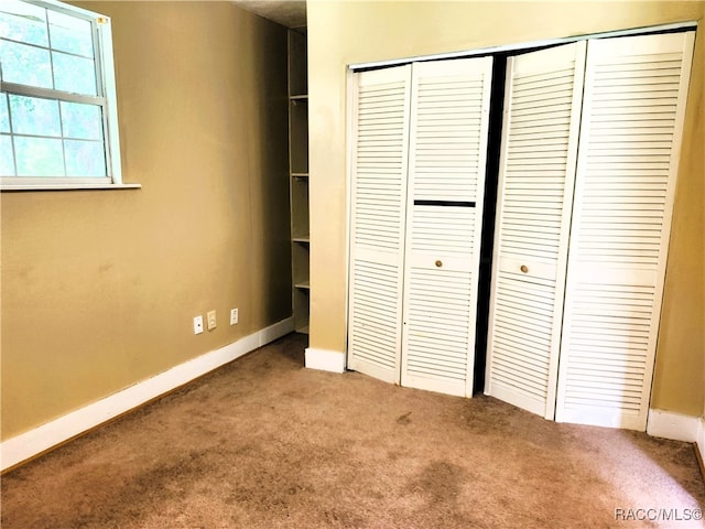 unfurnished bedroom with carpet flooring and a closet