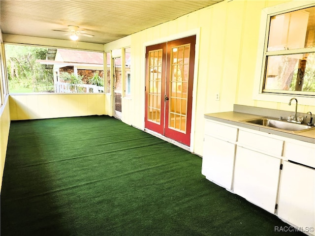 unfurnished sunroom with ceiling fan, sink, and wooden ceiling