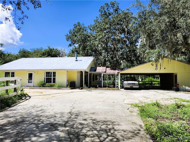 ranch-style home with a carport and central air condition unit