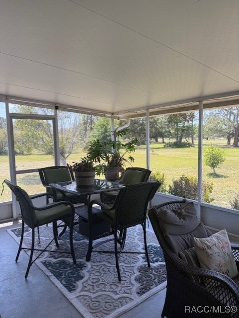 sunroom featuring outdoor dining area and plenty of natural light