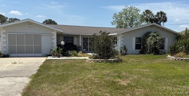 ranch-style home featuring an attached garage, a front lawn, and driveway
