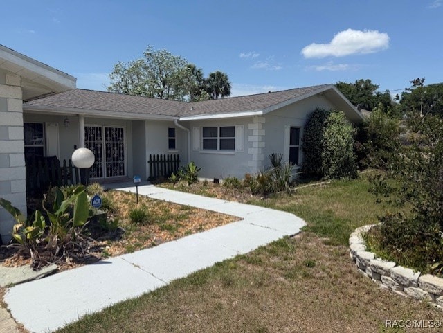 ranch-style home with stucco siding and a front yard