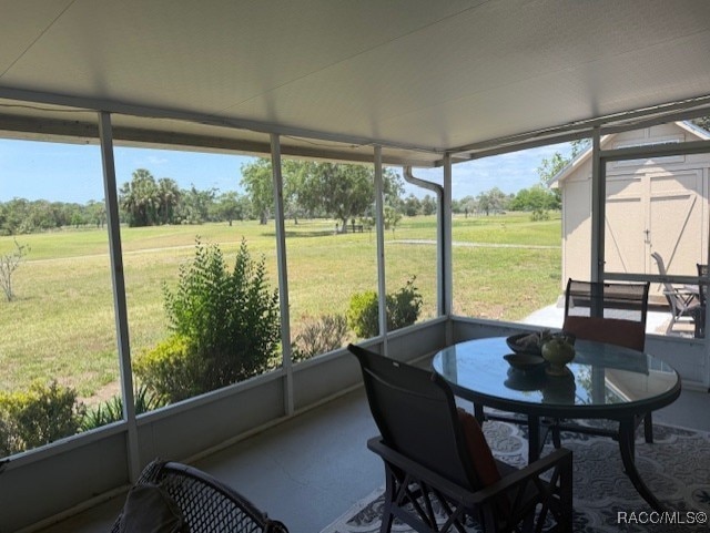 sunroom featuring plenty of natural light, a rural view, and outdoor dining space